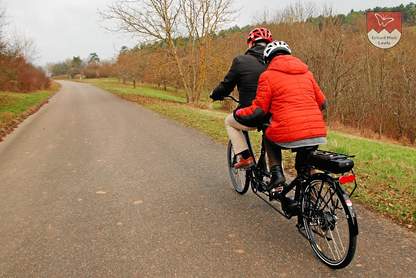 Steigung fahren mit dem E-Tandem Steigung fahren mit dem E-Tandem. Man erkennt deutlich, die Mitfahrerin strengt sich bei der ersten Probefahrt noch viel zu sehr an.