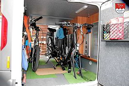 Tauber-Rad E-Tandem in der Wohnmobilgarage verstaut Teilbares Tauber-Rad Elektro-Tandem in der Wohnmobilgarage verstaut – auf Zweibeinständern, optional mit Vorderrad-Ausbau oder mittig geteilt.