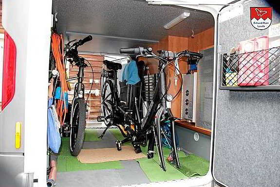 Tauber-Rad E-Tandem in der Wohnmobilgarage verstaut Teilbares Tauber-Rad Elektro-Tandem in der Wohnmobilgarage verstaut – auf Zweibeinständern, optional mit Vorderrad-Ausbau oder mittig geteilt.