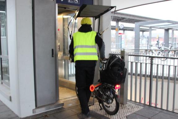 Vitali E-Faltrad im Aufzug am Bahnhof Pendler schiebt ein Vitali E-Faltrad in den Aufzug am Bahnhof